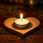 Candle in a heart-shaped holder on a patterned fabric background with mdf tealight candle holder.