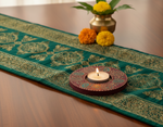 Decorative table runner with a candle and flowers on a wooden surface with handpainted mdf tealight candle holder.