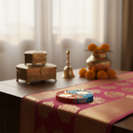 Decorative setting with candles, a bell, and decorative items on a table with handpainted tealight candle holder.