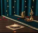 Decorative setup with a lit candle, brass lamp, and statue on a table with a blue curtain background with lit mdf tealight candle holder.
