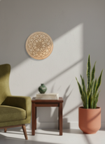 Living room with green armchair, wooden side table, and potted plant against a white wall with a decorative MDF DIY mandala wall art piece.