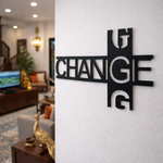 Modern black typography wall décor featuring the word “CHANGE” in a stylish geometric design mounted on a white wall in a contemporary living room setting.