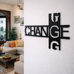Modern black typography wall décor featuring the word “CHANGE” in a stylish geometric design mounted on a white wall in a contemporary living room setting.