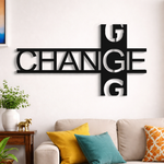 Modern black typography wall décor featuring the word “CHANGE” in a stylish geometric design mounted on a white wall in a contemporary living room setting.