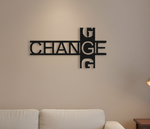 Modern black typography wall décor featuring the word “CHANGE” in a stylish geometric design mounted on a white wall in a contemporary living room setting.