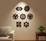 Seven chakra MDF wall decor set with spiritual symbols arranged symmetrically on a wall in a modern meditation space.