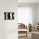 Black MDF wall décor with cut-out word “THINK” mounted on a light-colored wall in a modern living room setting.