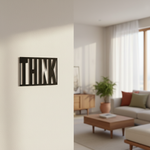 Black MDF wall décor with cut-out word “THINK” mounted on a light-colored wall in a modern living room setting.