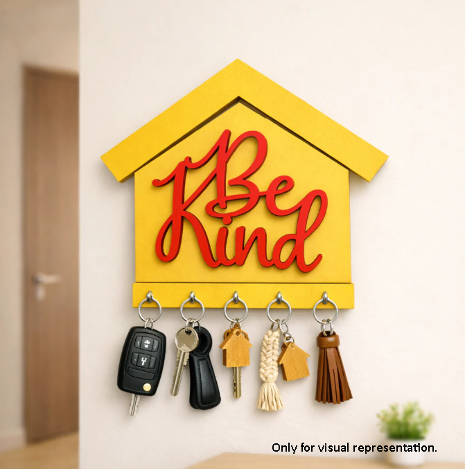 MDF DIY Yellow painted "Be kind" key holder with keys hanging on the wall.
