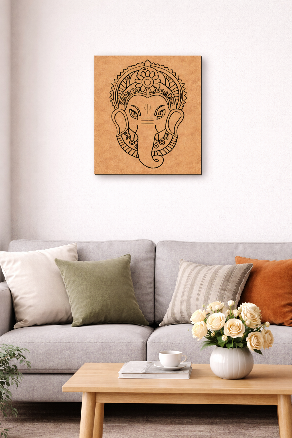 Decorative MDF DIY wall art of an ganesh picture on a beige wall above a gray sofa with colorful cushions.