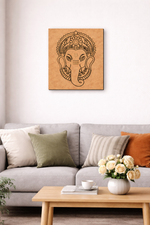 Decorative MDF DIY wall art of an ganesh picture on a beige wall above a gray sofa with colorful cushions.