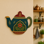 Decorative teapot-shaped MDF wall art with botanical patterns mounted on a warm beige kitchen wall.