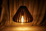 Matte black cage‑style ceiling pendant lamp with glowing Edison bulb and black hanging cord