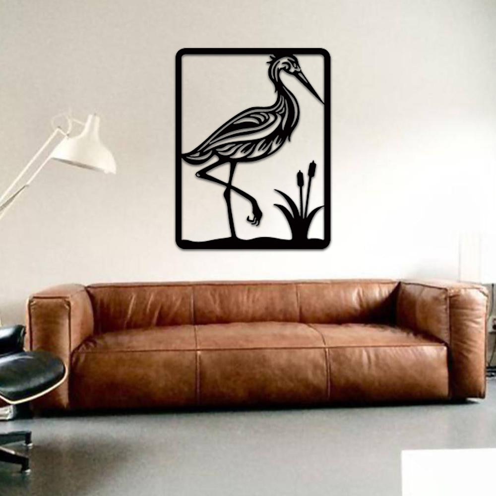Elegant black MDF wall art featuring a heron standing near water plants, mounted on a modern living room wall above a brown leather sofa.