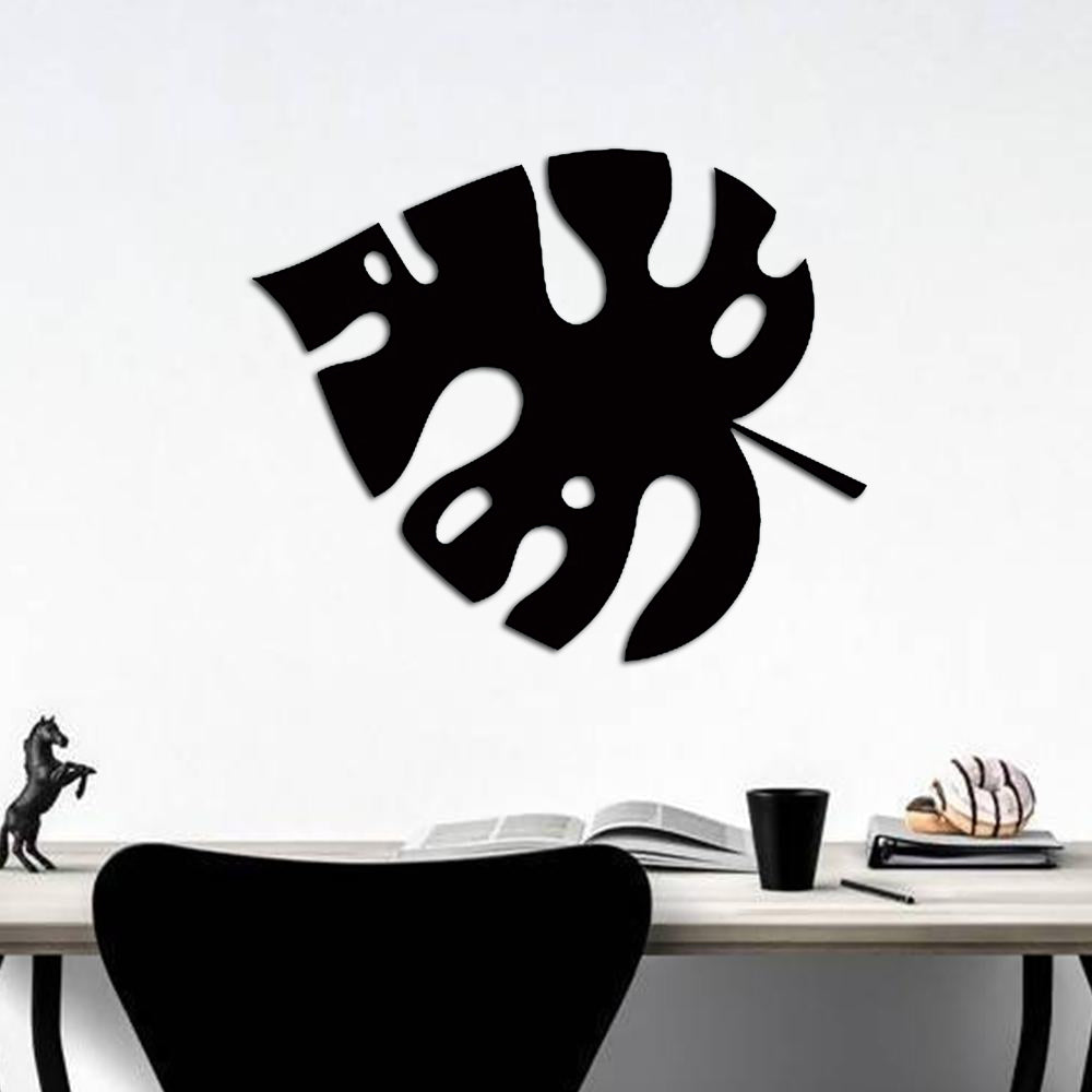 Black palm leaf wall art displayed above a minimalist desk setup.