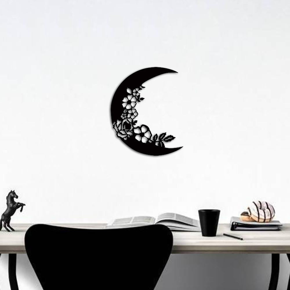 Crescent moon wall decor in black with intricate floral designs, mounted above a sleek desk setup.