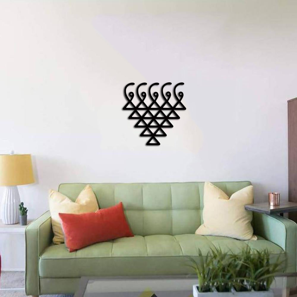 Geometric wall art in black MDF, featuring a modern triangular pattern, mounted on a living room wall.