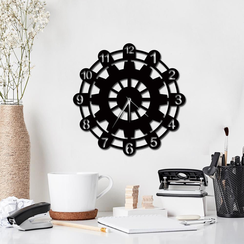 Stylish black wheel wall clock with a modern design displayed in a minimalist workspace.