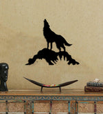 Black MDF wolf wall decor featuring a silhouette of a howling wolf standing on a rock, mounted on a beige wall above a wooden console table