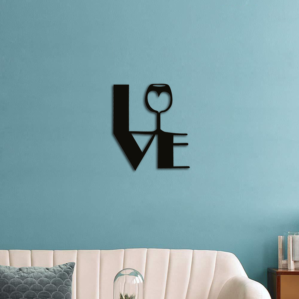 Black love-themed wall art featuring a wine glass design incorporated into the word 'LOVE,' mounted on a blue wall above a modern white couch.