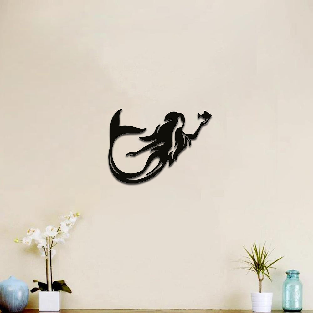 Elegant mermaid silhouette wall art in black displayed on a beige wall with minimalist decor elements.