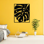 Elegant black palm design wall art displayed in a cozy living room with yellow wall.