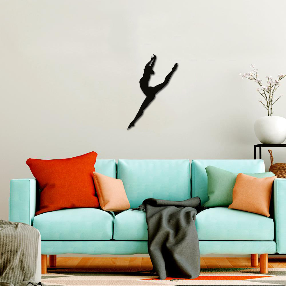 Black gymnast wall art featuring a silhouette of a gymnast in a dynamic pose, mounted on a light-colored wall above a pastel blue sofa.