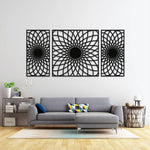 Set of three black MDF wall art panels with intricate geometric patterns, mounted on a white wall above a modern gray sectional sofa in a stylish living room.