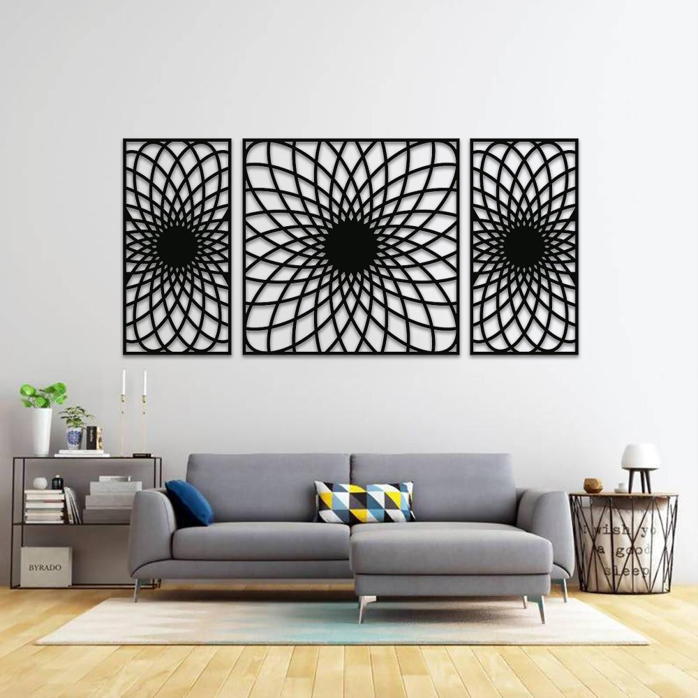Set of three black MDF wall art panels with intricate geometric patterns, mounted on a white wall above a modern gray sectional sofa in a stylish living room.