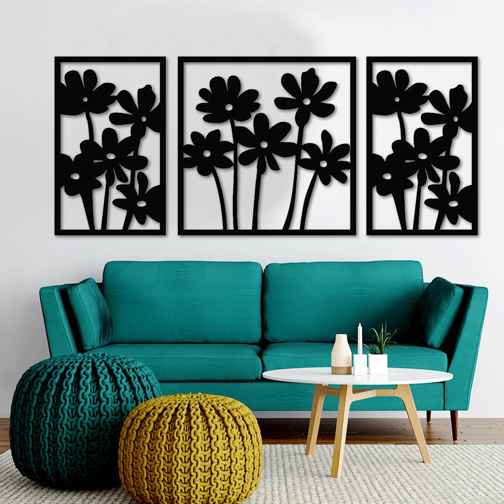 Modern living room wall decor featuring a set of three black floral frames arranged on a concrete-textured wall above a stylish sofa .