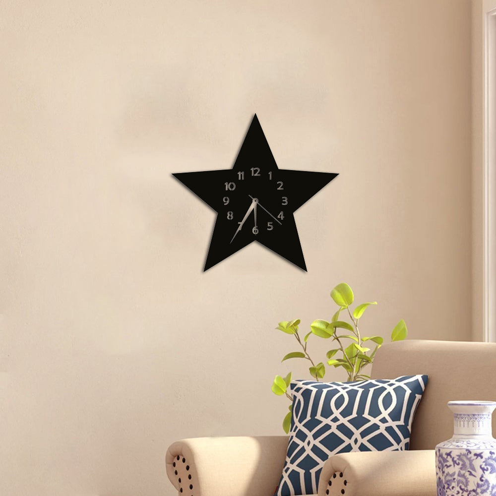 Black star-shaped MDF wall clock with white numerals, elegantly mounted on a neutral-colored living room wall above a cozy seating area.