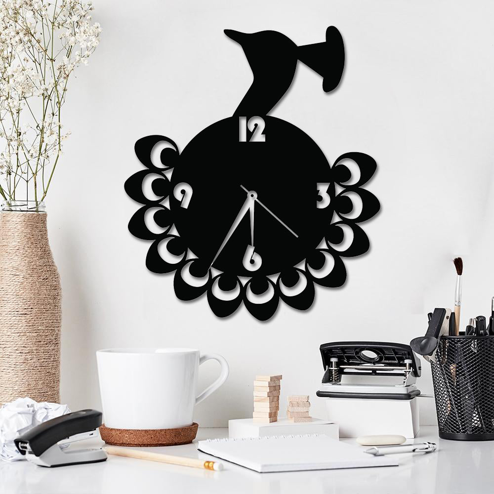 Elegant black peacock wall clock with intricate feather detailing, displayed in a stylish workspace.