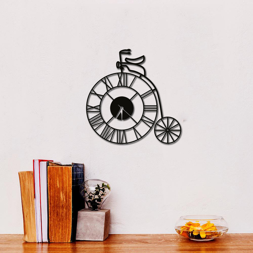 Stylish cycle wall clock with Roman numerals, designed in a vintage bicycle shape, mounted on a white wall.