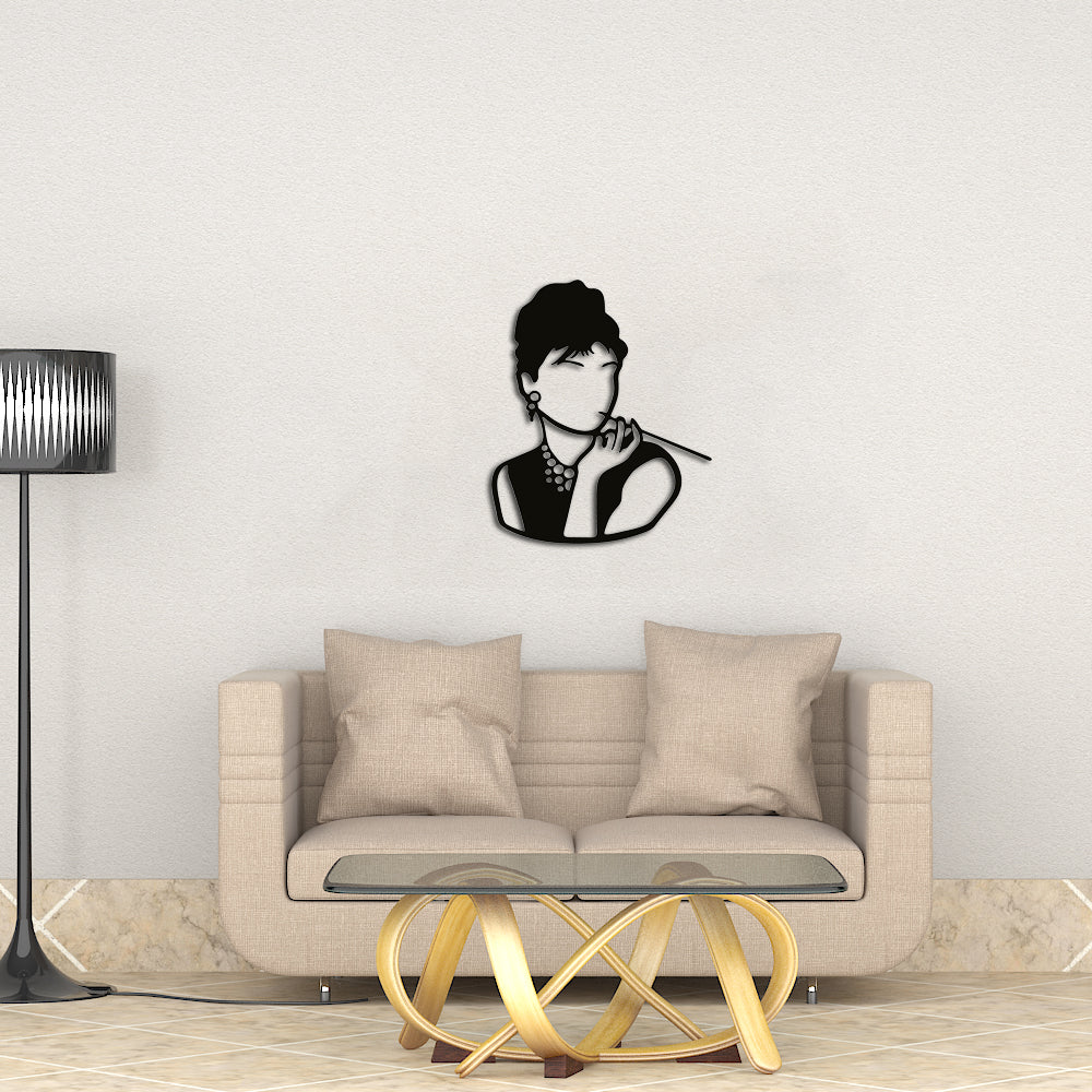 Wall art of a vintage woman silhouette with elegant details, mounted above a beige sofa in a modern living room setting